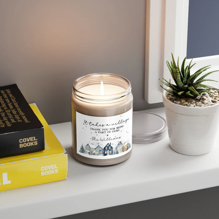 Thank You gift - Personalized Holiday Village Soy Candle on a windowsill with books and a small plant.