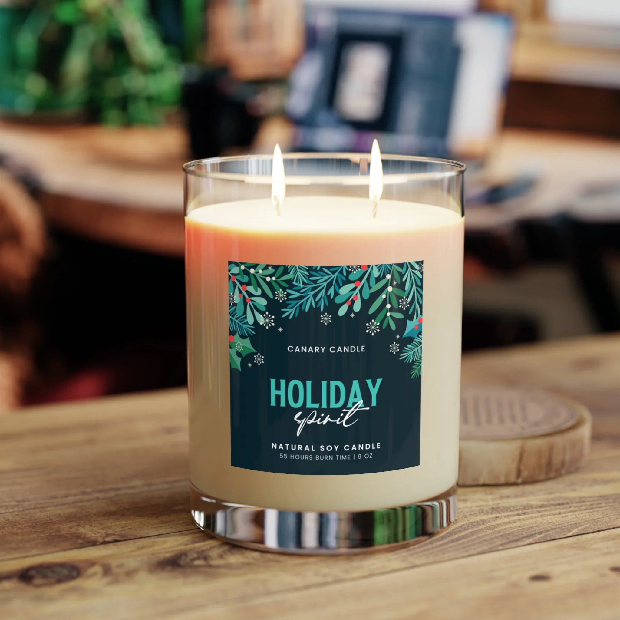 Holiday Spirit Scented Candle 11oz with dual wicks, in a cozy room setting, emitting a warm glow.
