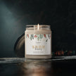 Winter berries scented candle in reusable glass jar with glossy label, glowing candlelight on dark background.