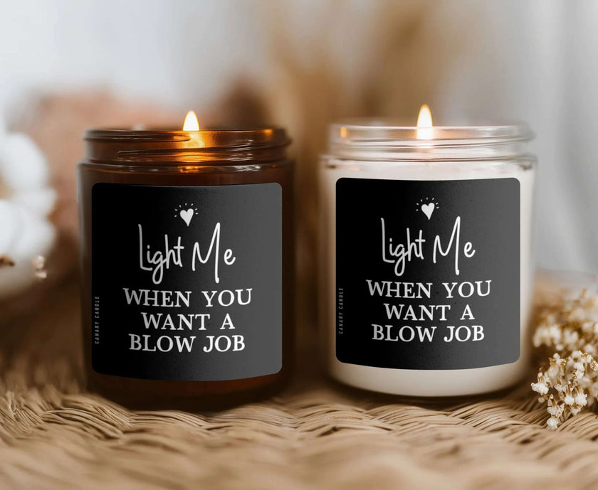 Naughty Soy Candle — Light Me When You Want A BJ in amber and clear jars with lit wicks.