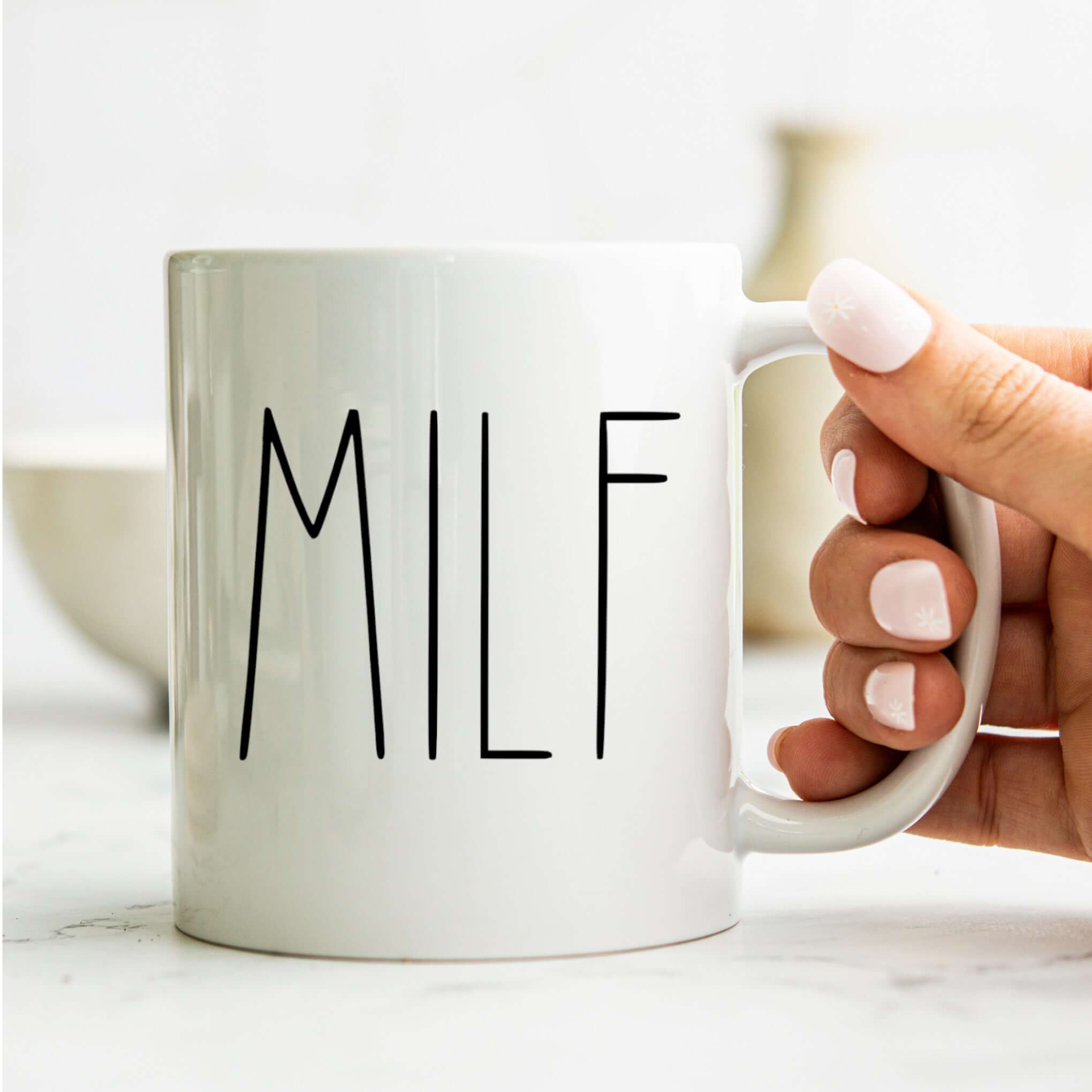 Hand holding MILF Coffee Mug — Funny New Mom Gift Ceramic Mug (11oz & 15oz) with a clean, modern design, PERSONALIZED