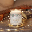 Winter berries scented candle in a glass jar with a glossy label, surrounded by fairy lights and an acoustic guitar.